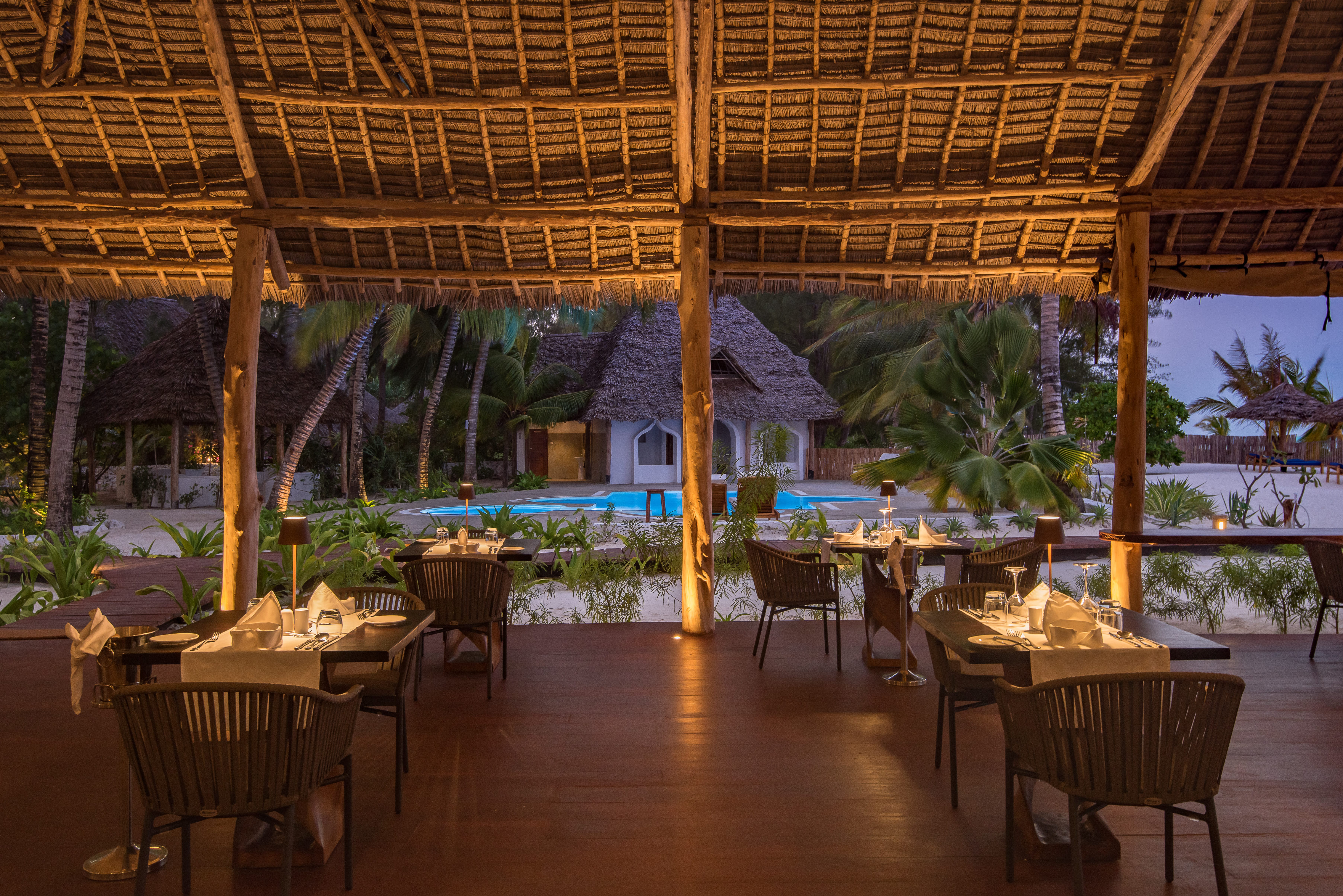 a group of tables and chairs next to a pool