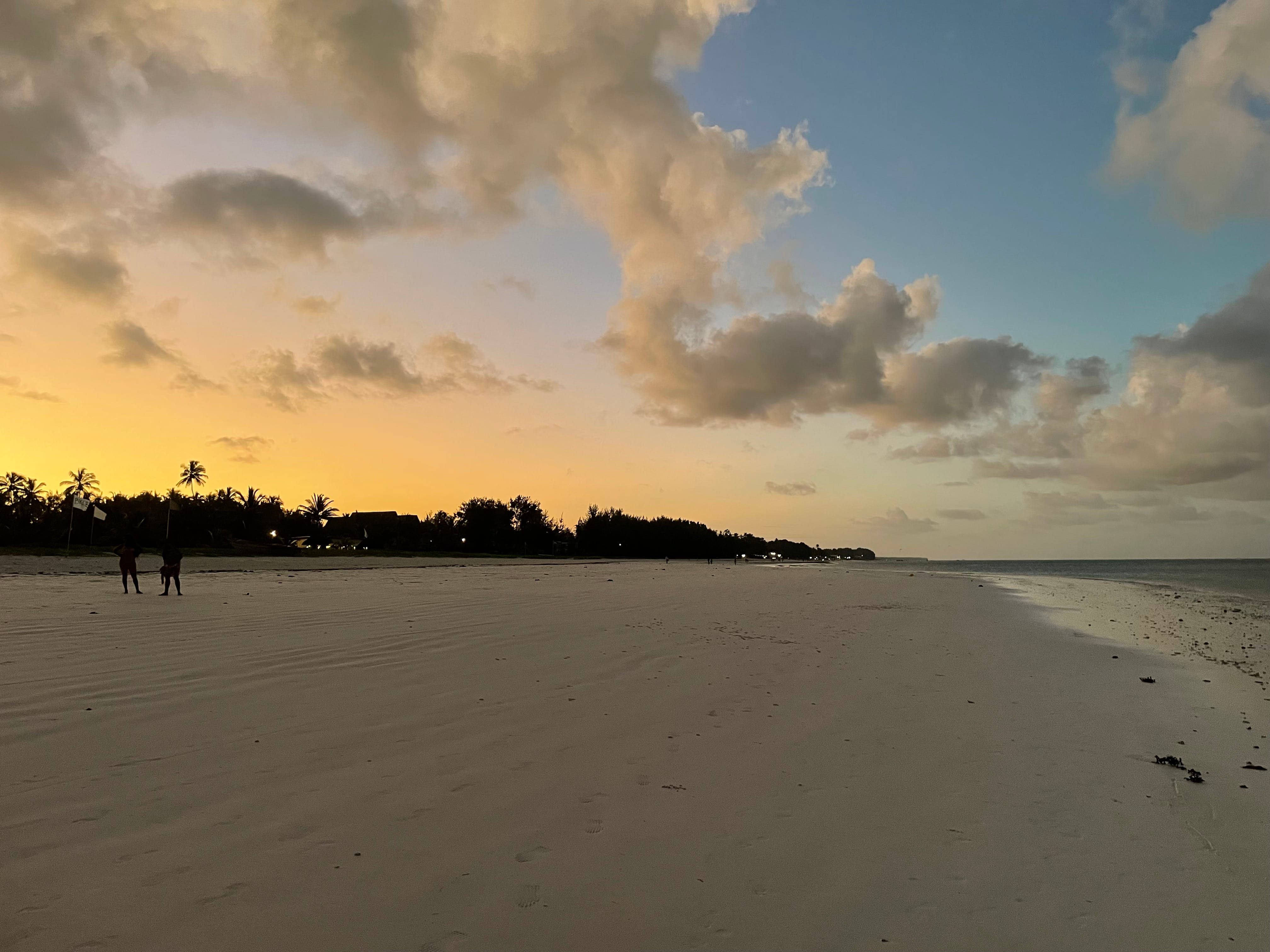 a beach with people walking on it