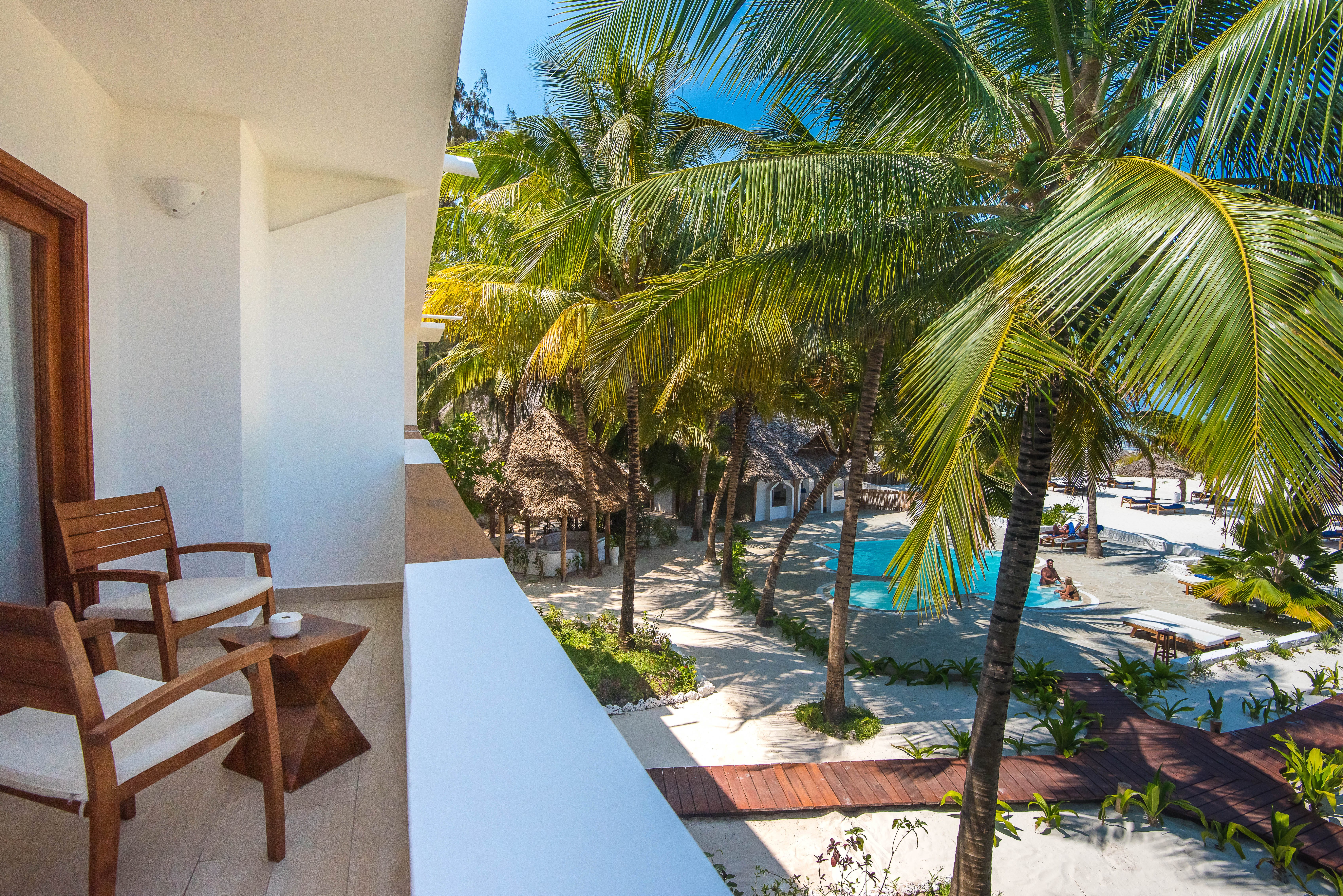 a pool with palm trees and chairs