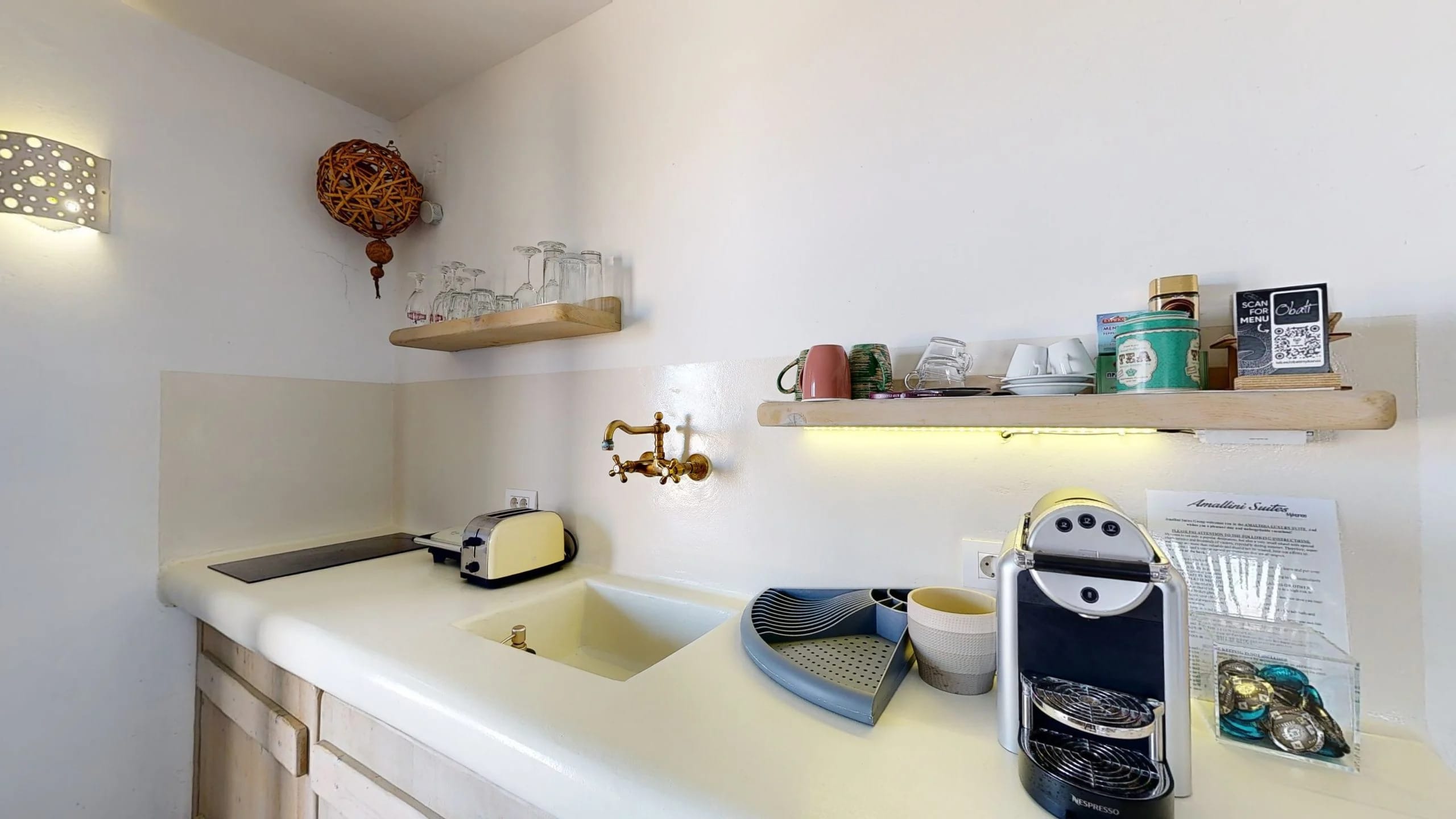 a kitchen counter with a sink and a shelf with objects on it
