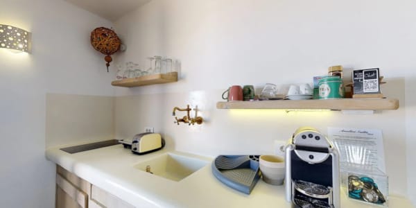 a kitchen counter with a sink and a shelf with objects on it
