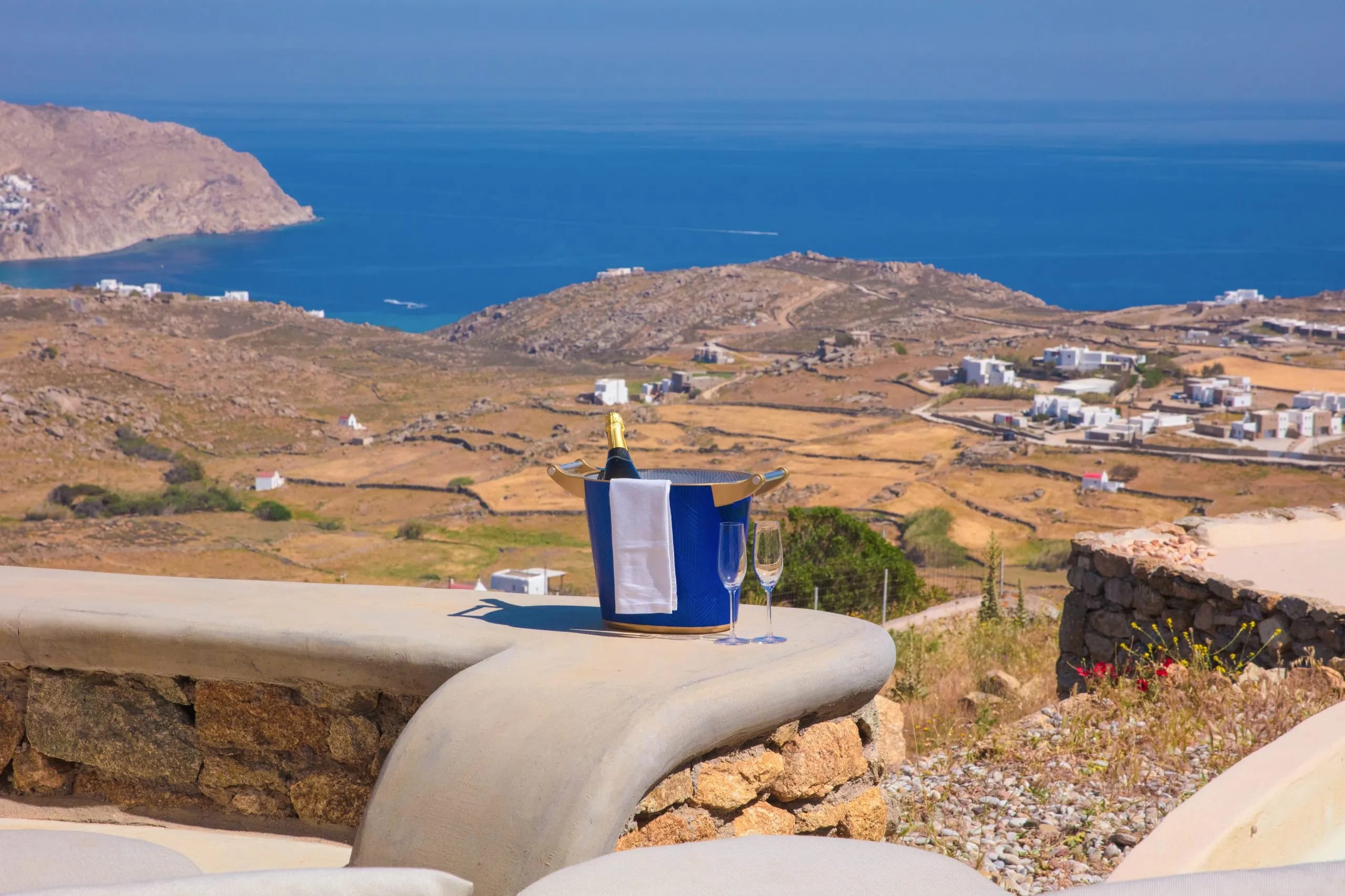 a blue and white building on a rock overlooking a town and water