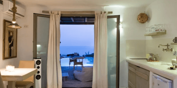 a room with a view of the ocean and a cat sitting on the floor