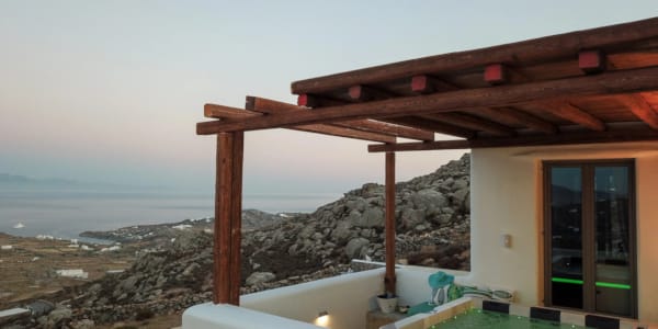 a building with a view of the ocean and a hill in the background