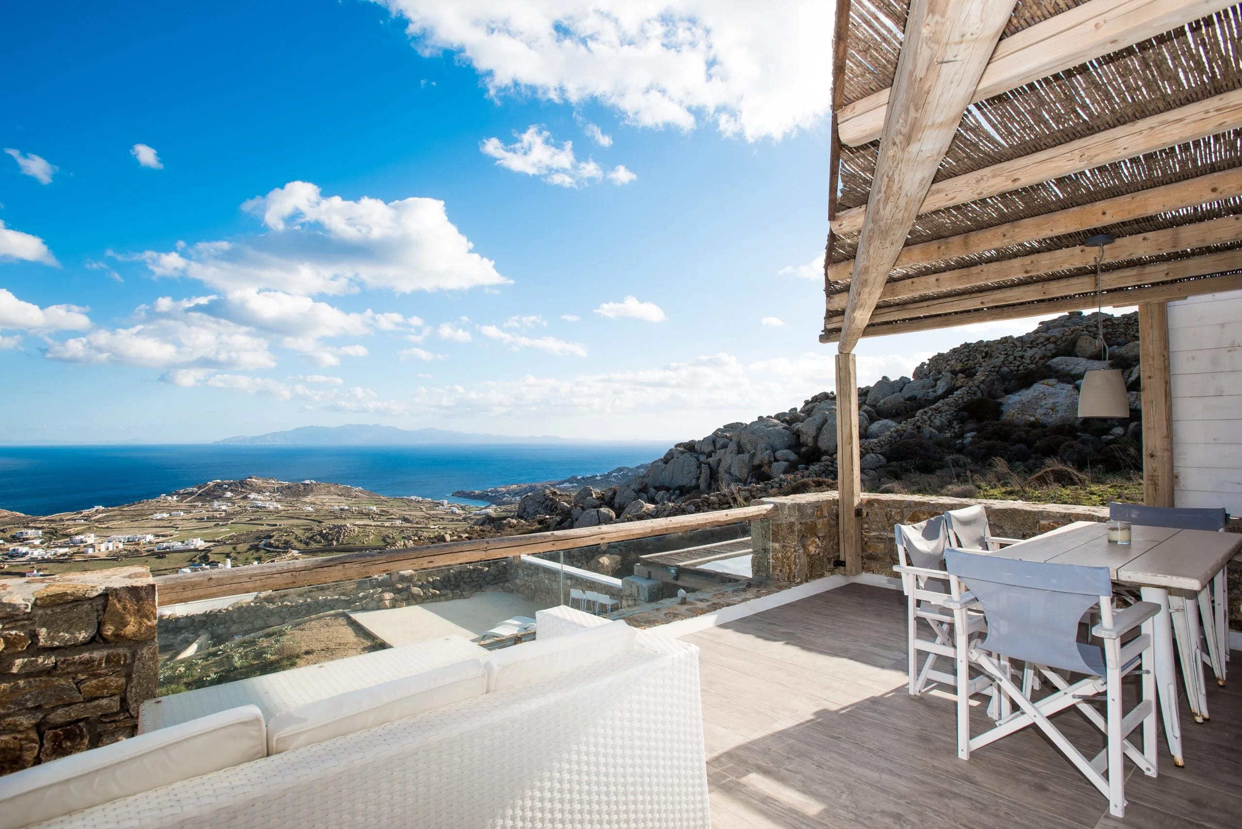 a deck with a table and chairs on it overlooking a city
