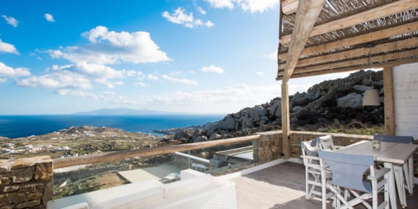 a deck with a table and chairs on it overlooking a city