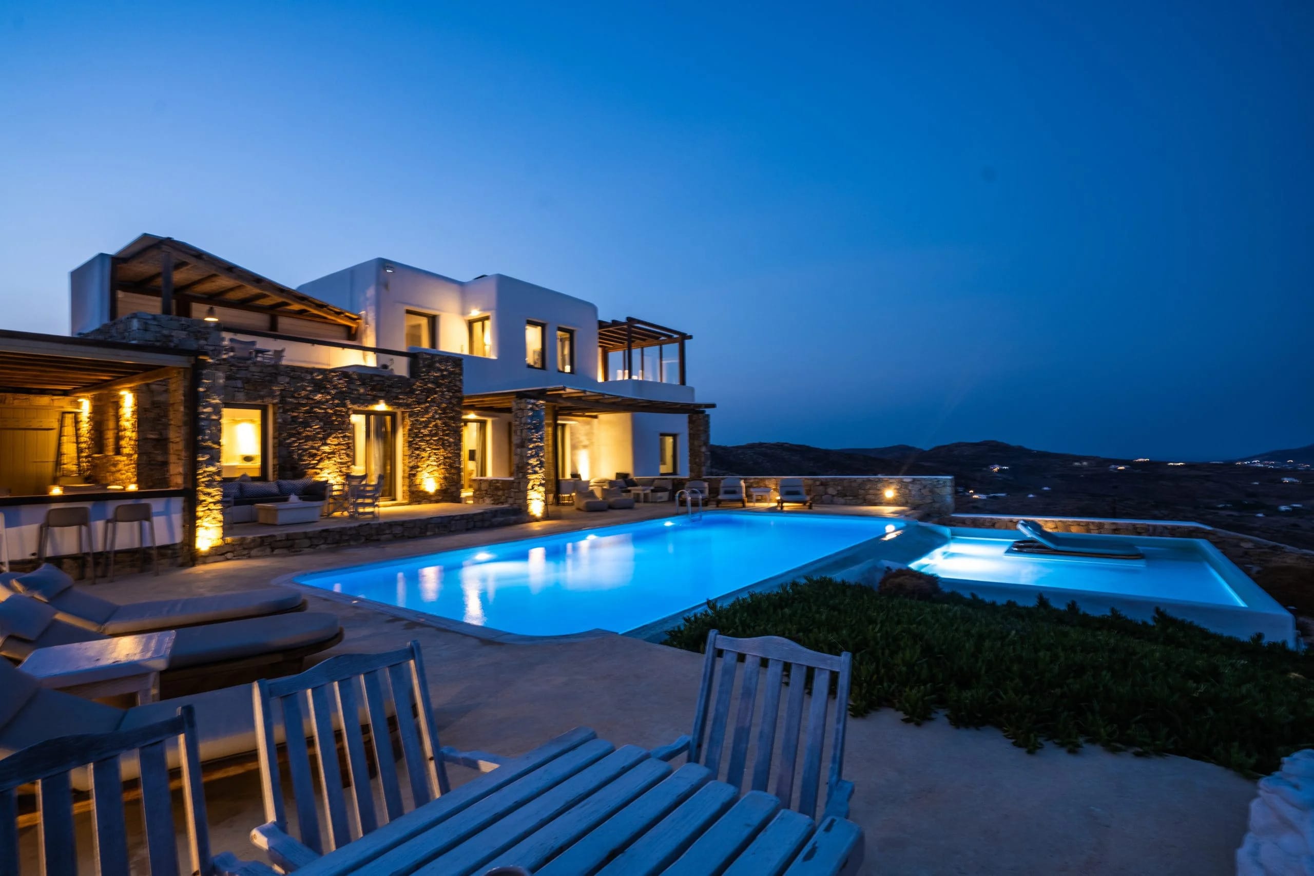 a house with a pool and a deck with a view of the ocean