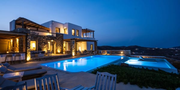 a house with a pool and a deck with a view of the ocean
