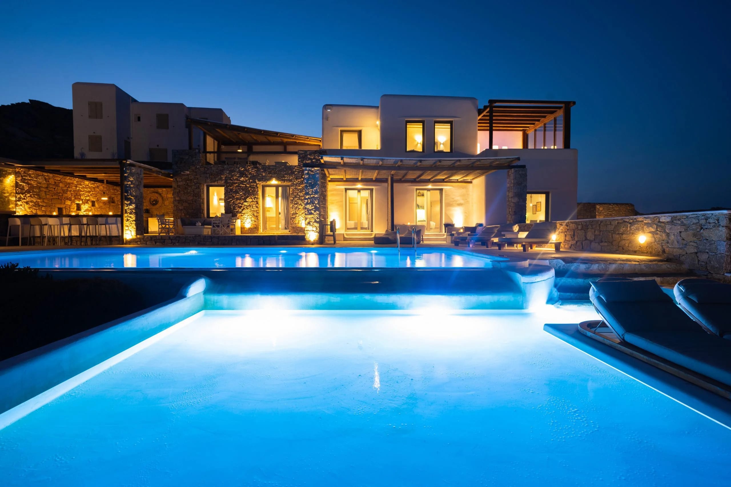 a house with a pool in front of it at night