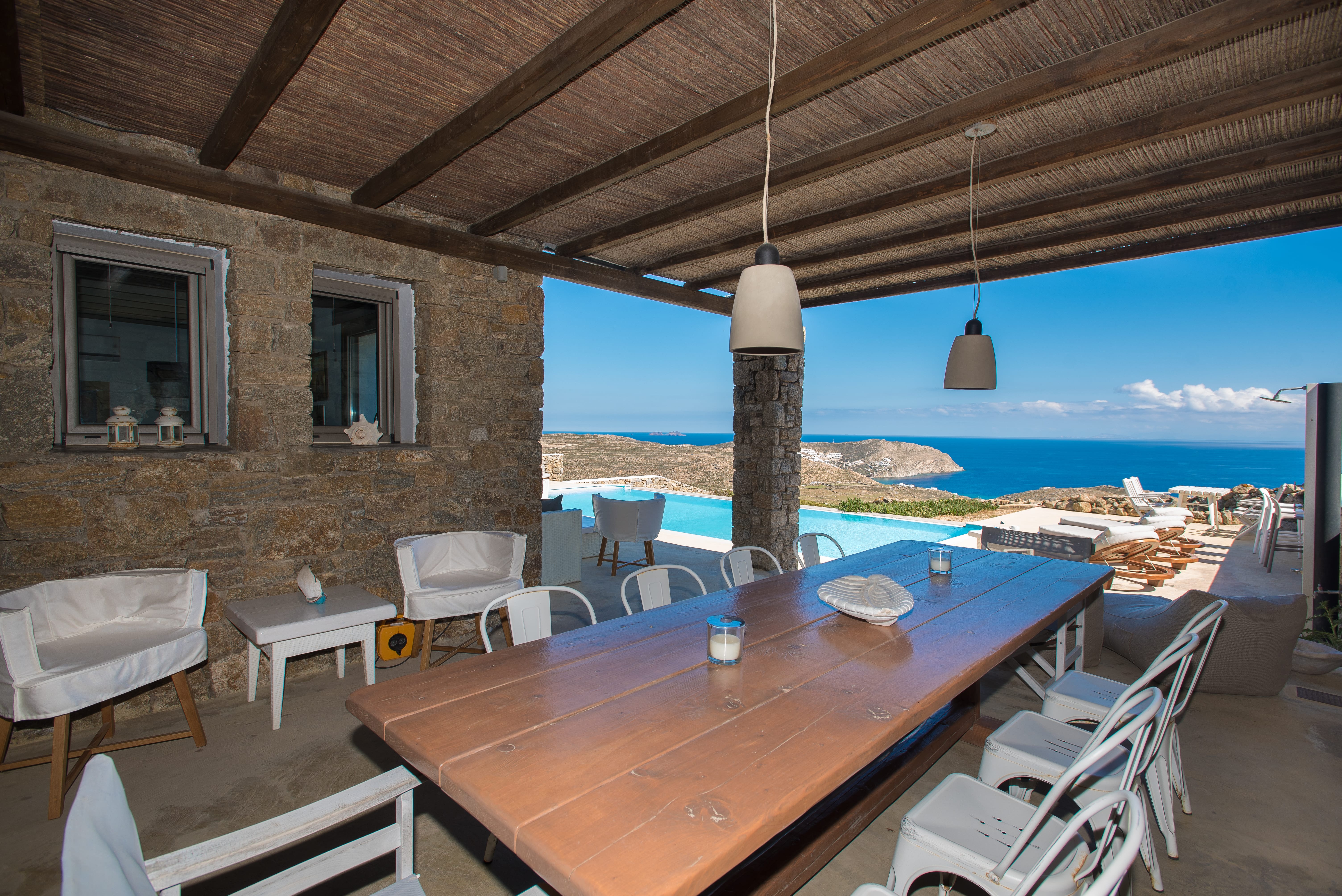 a table with chairs and a view of the ocean