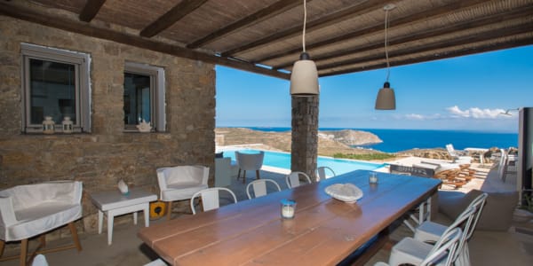 a table with chairs and a view of the ocean