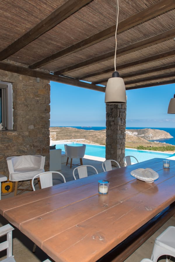 a table with chairs and a view of the ocean