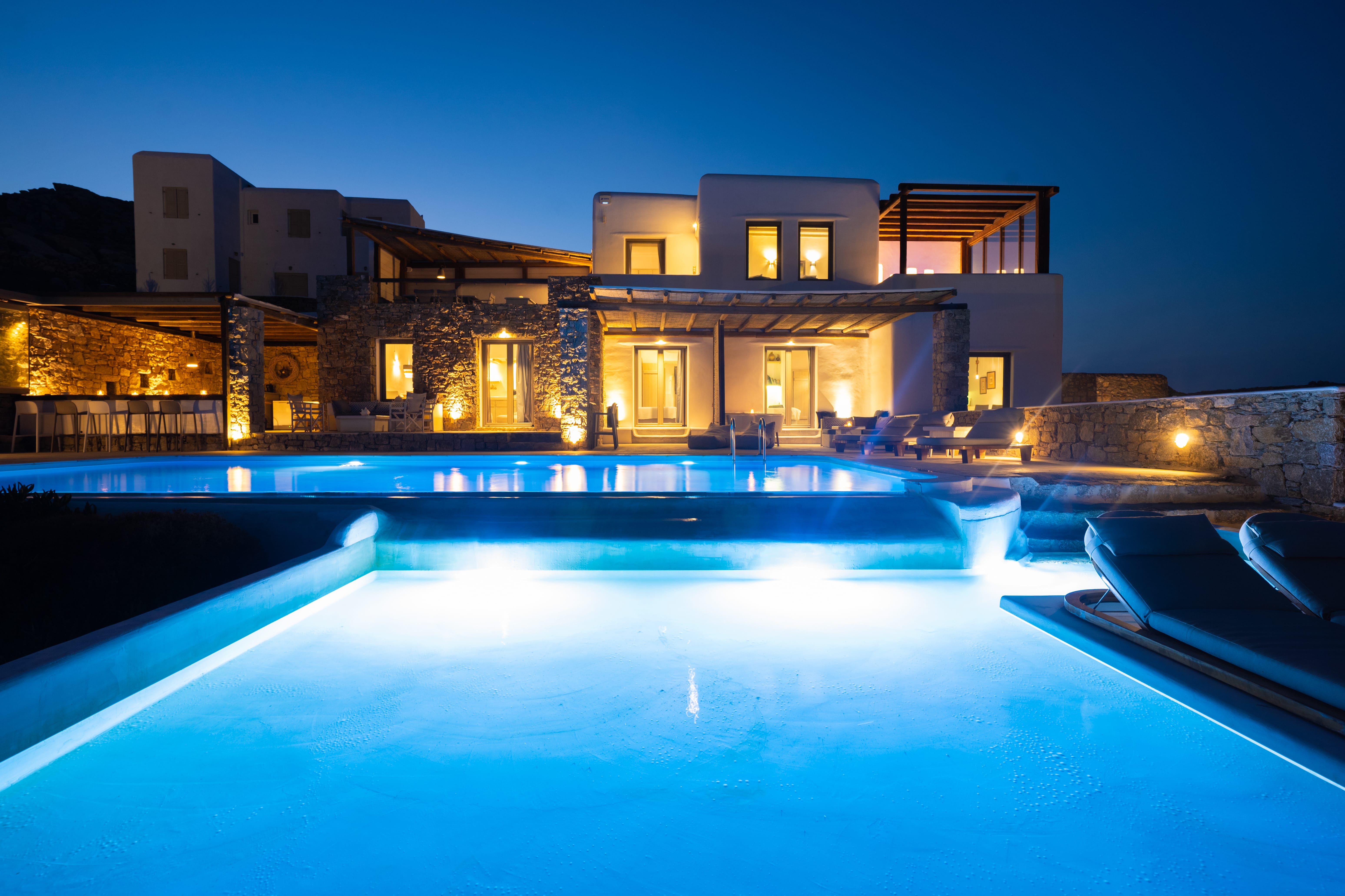 a house with a pool in front of it at night