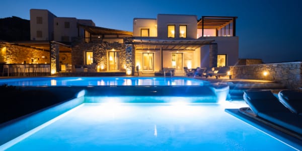 a house with a pool in front of it at night