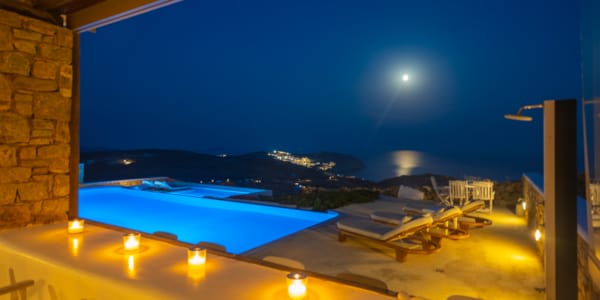 a pool with a view of the ocean and mountains in the background