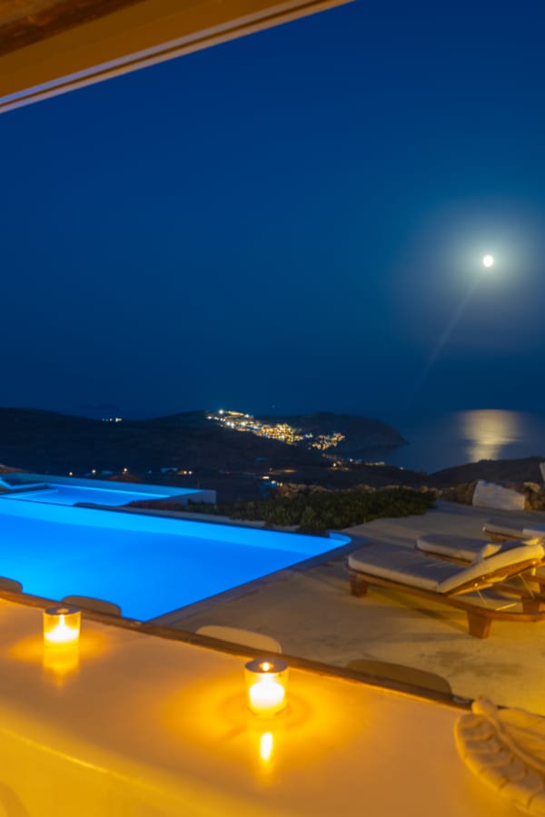a pool with a view of the ocean and mountains in the background