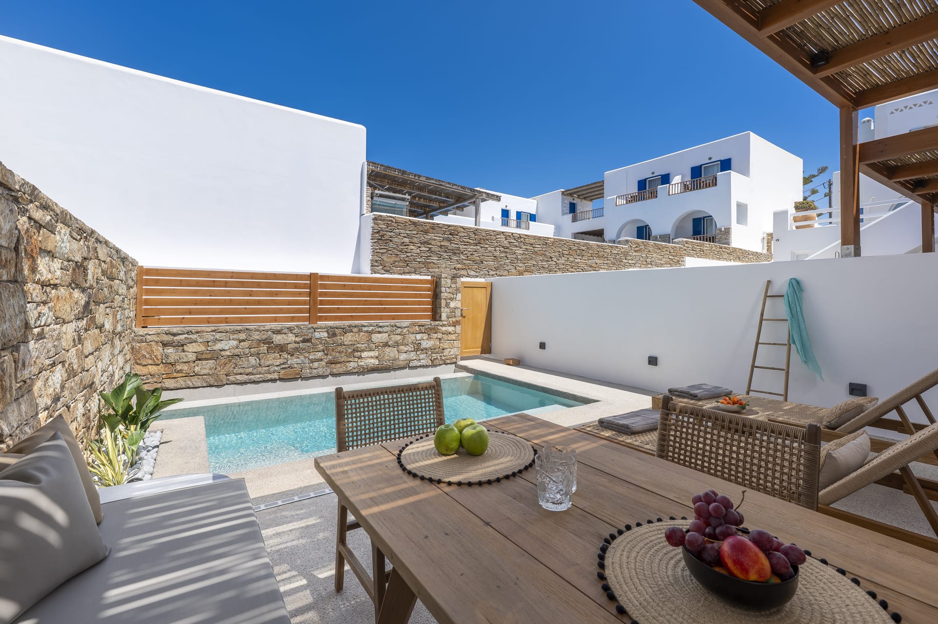 a table and chairs next to a pool