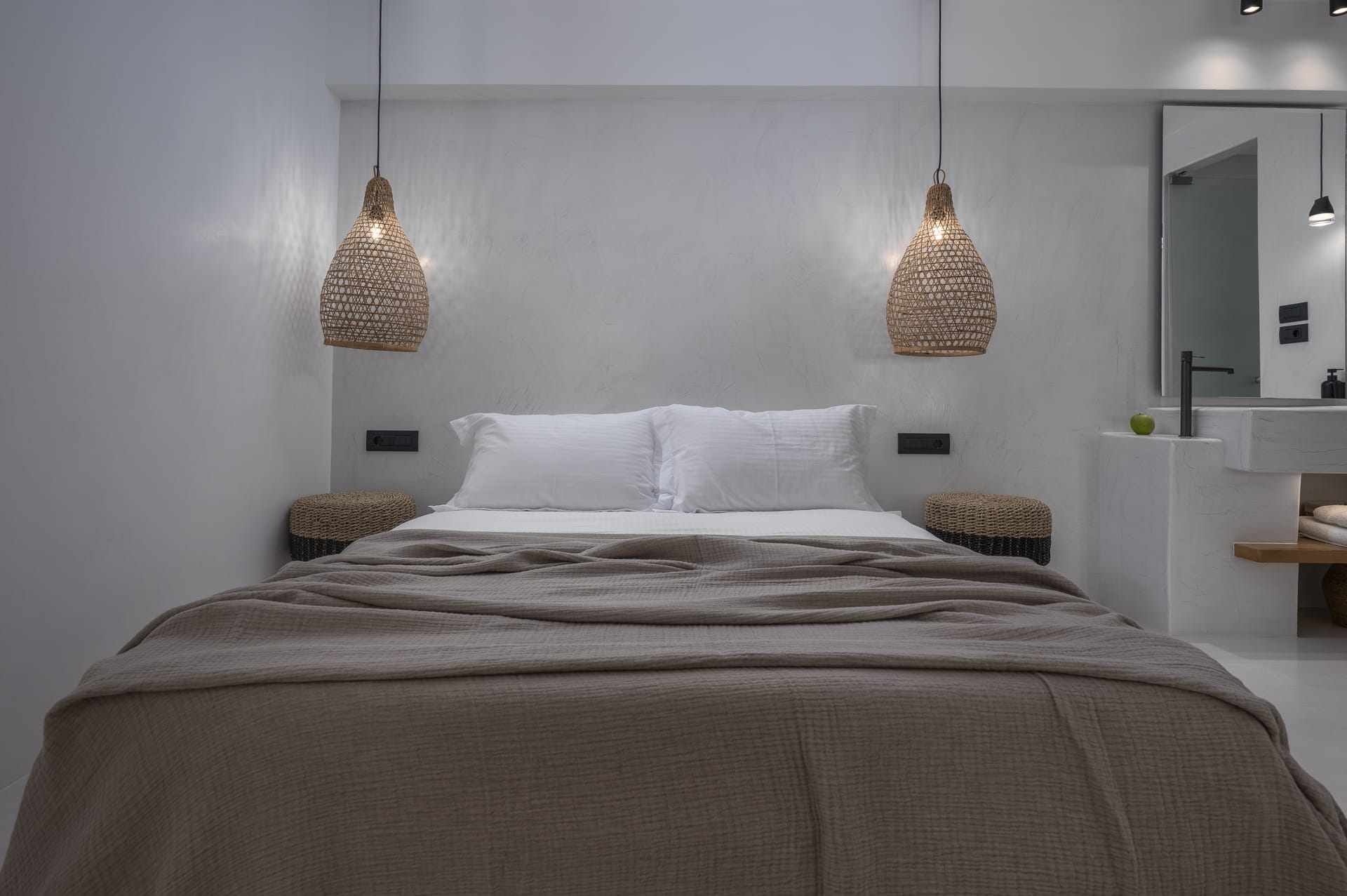 a bed with a lamp on the wall