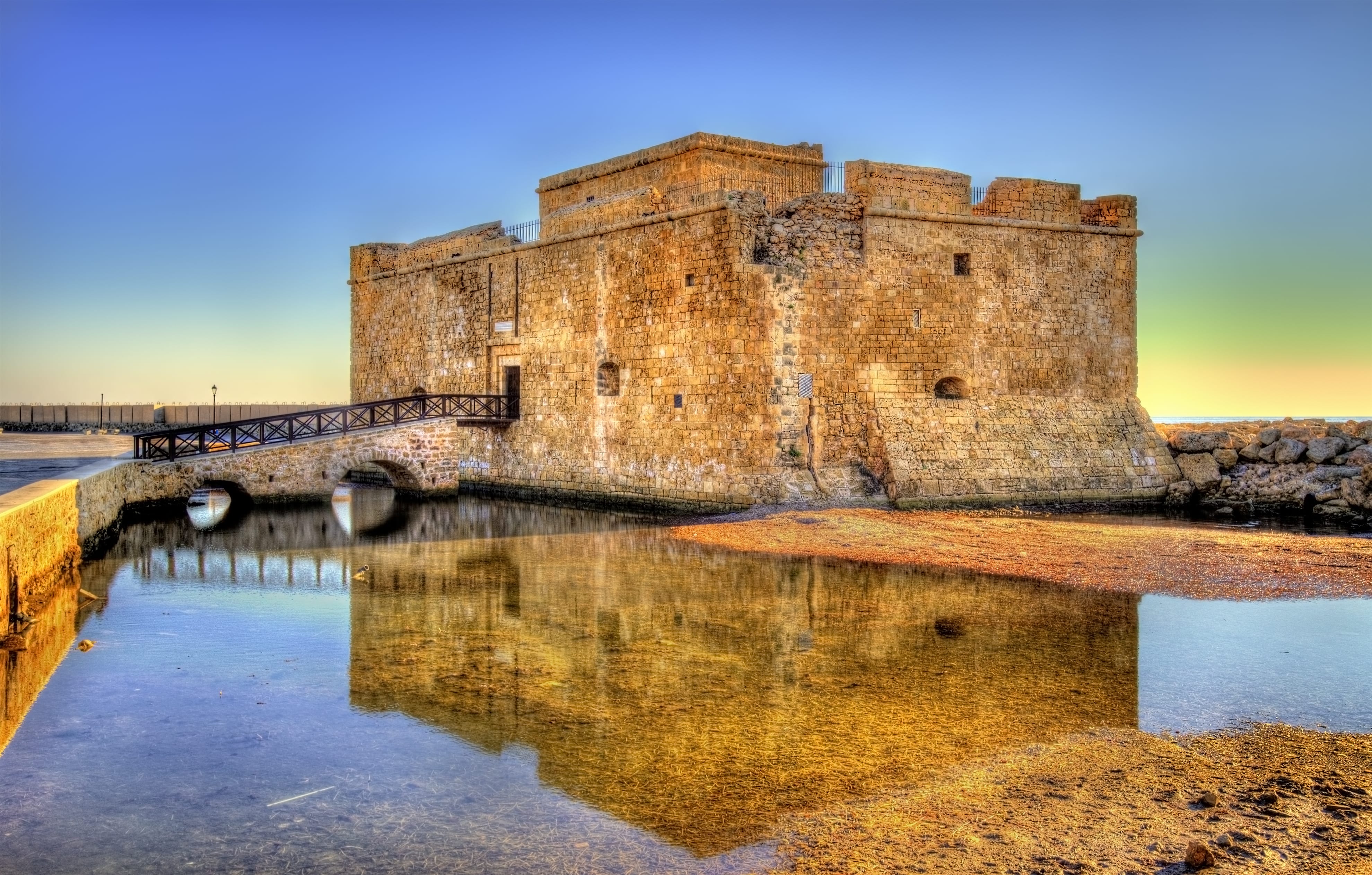 a stone castle on a hill with Paphos Castle in the background