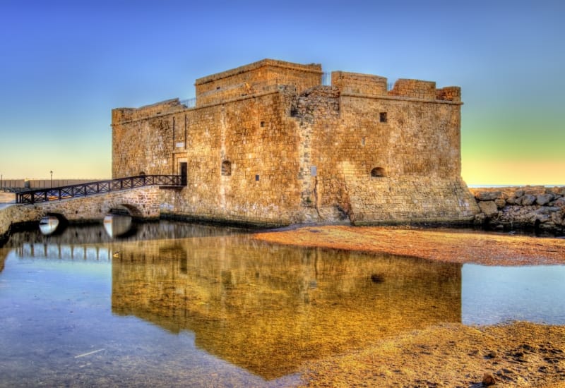 a stone castle on a hill with Paphos Castle in the background