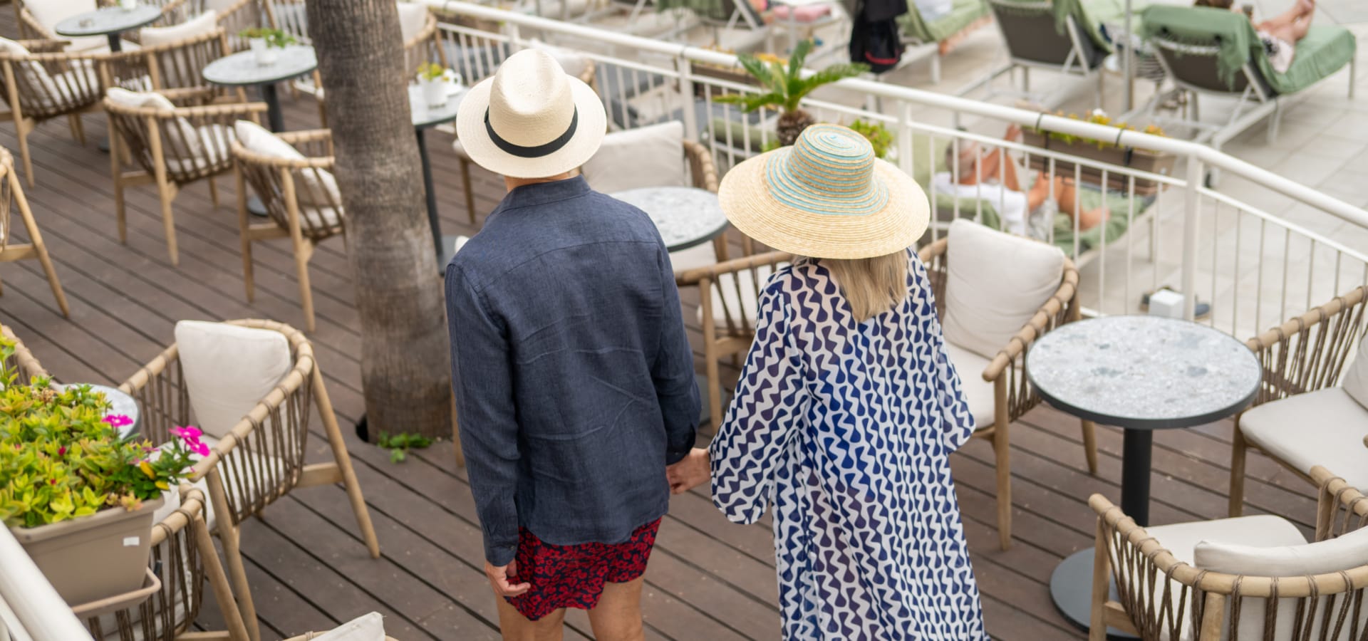 a man and woman walking on a boardwalk