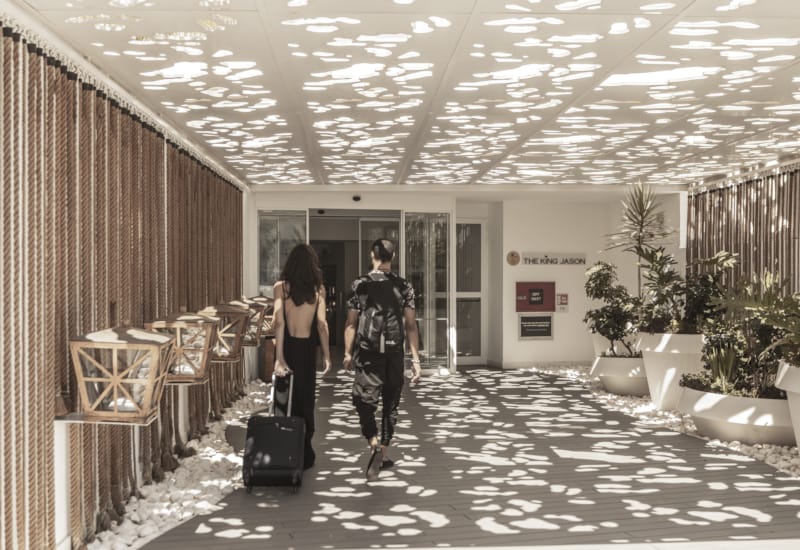 a couple of people walking down a hall with their luggage