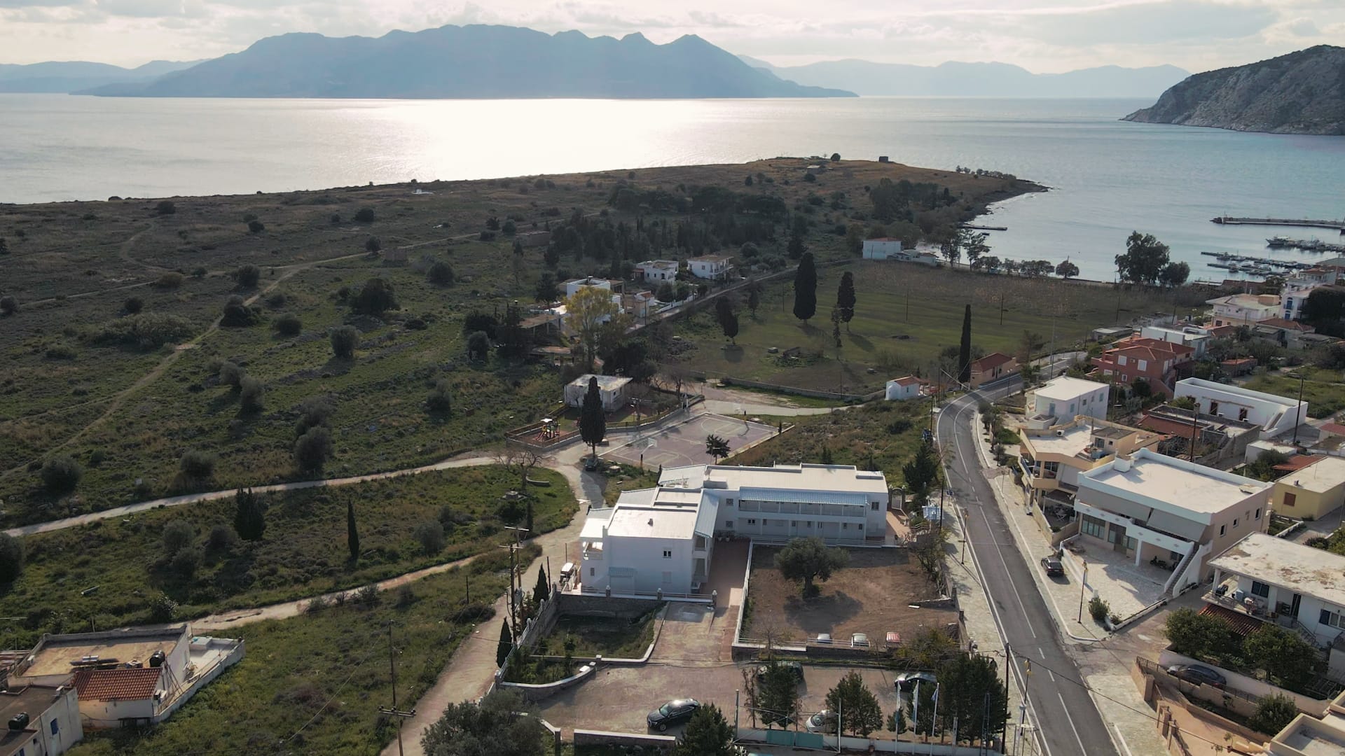 a landscape with buildings and trees by the water