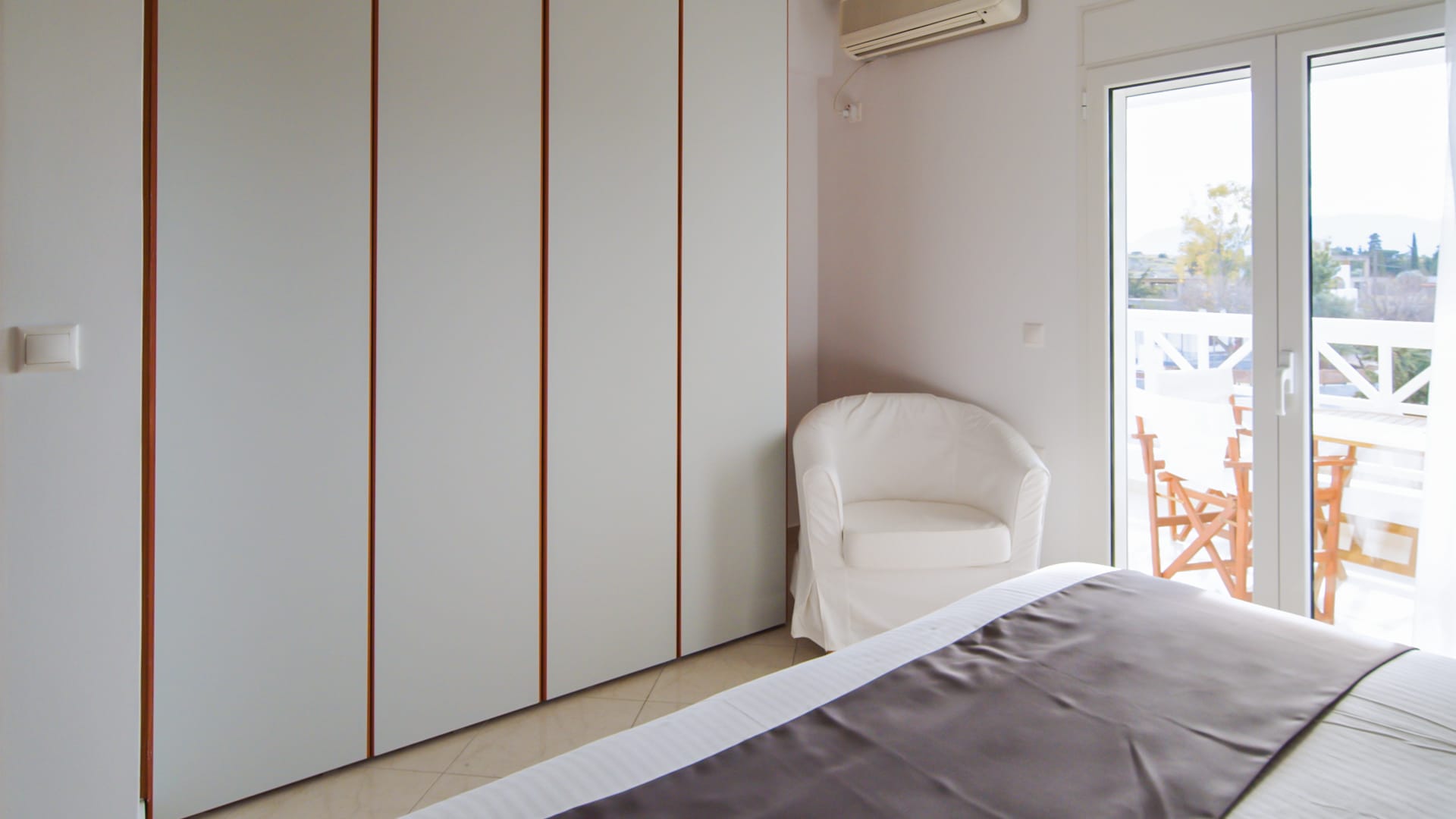 a bedroom with a chair and a window