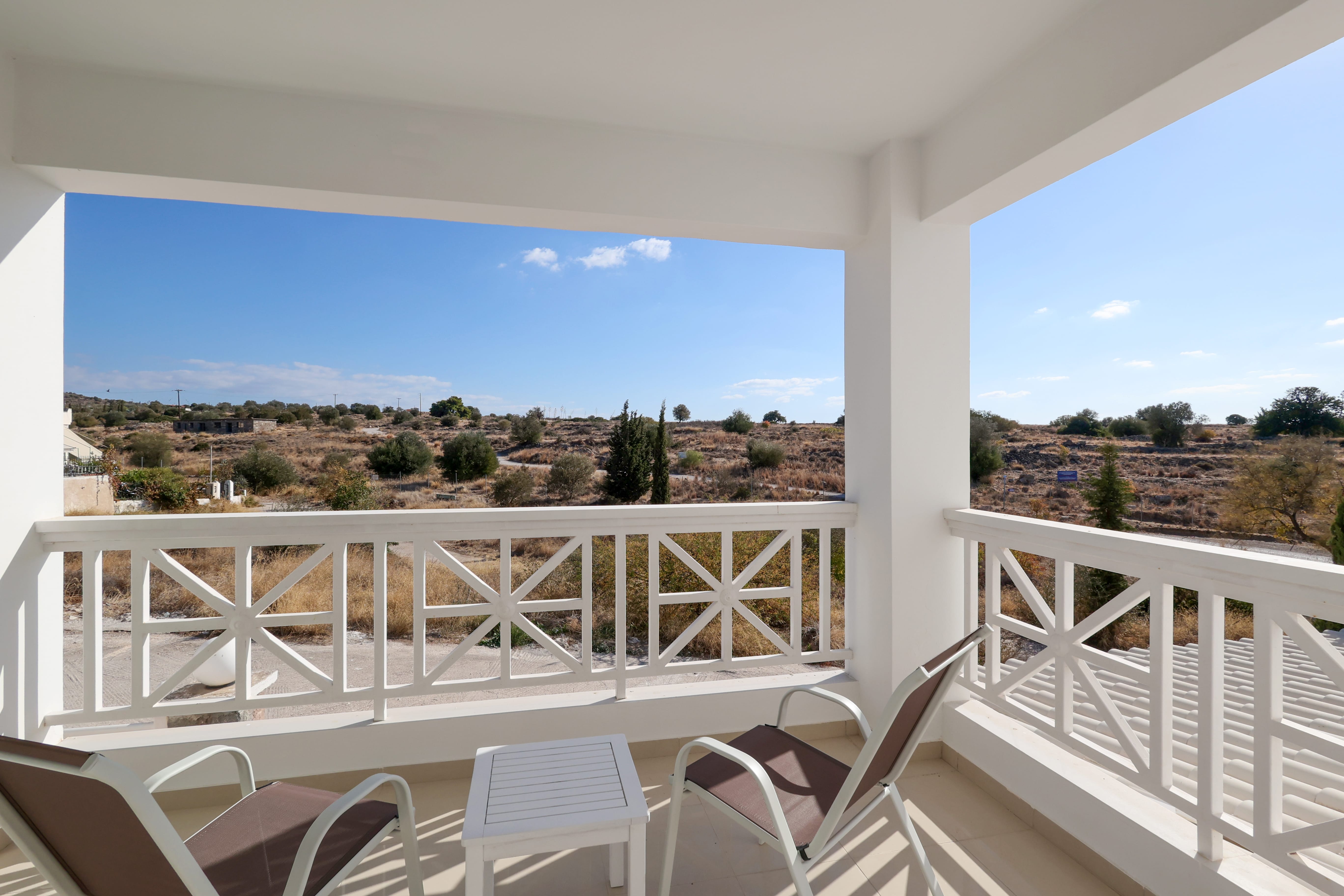 a balcony with white chairs