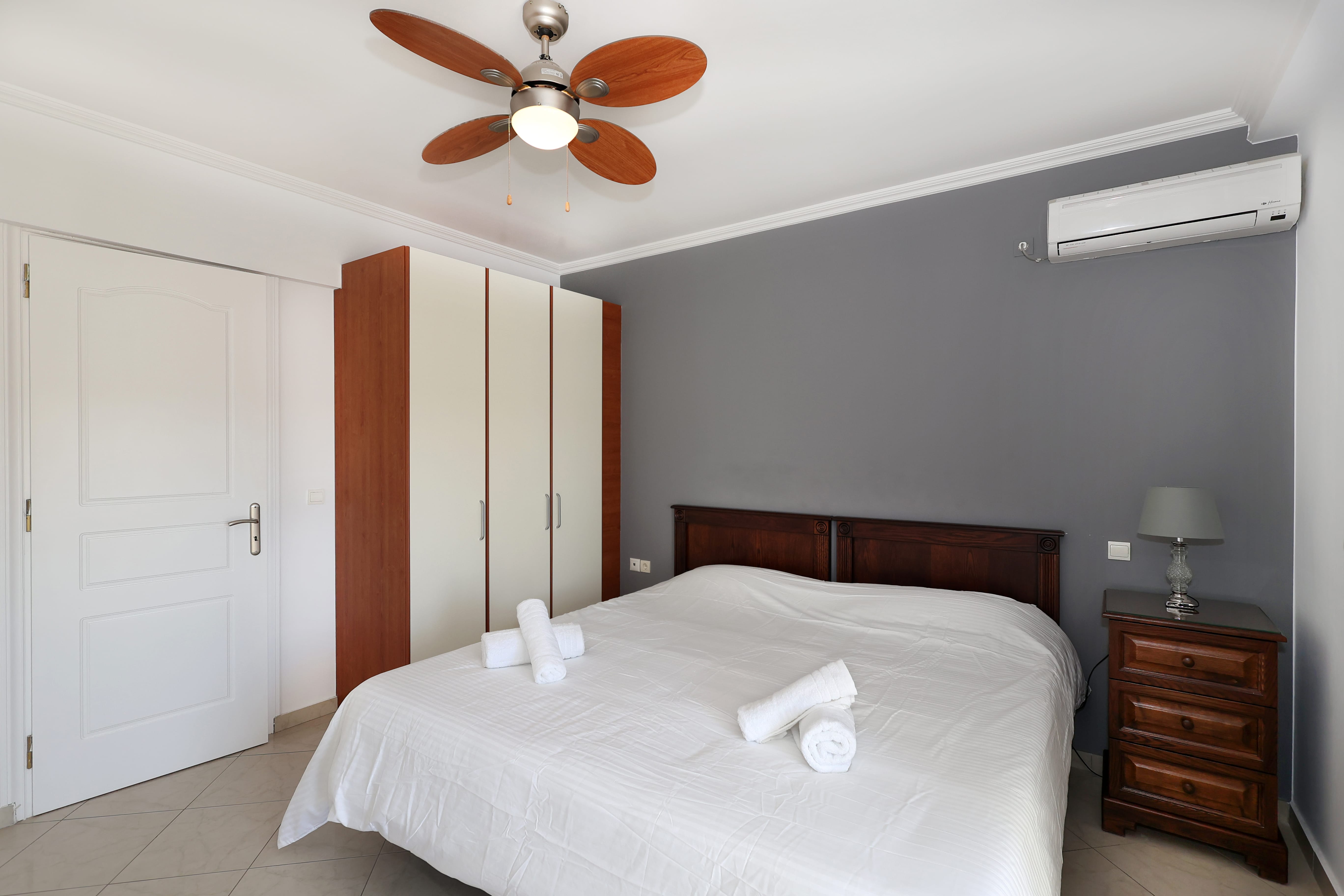 a bedroom with a ceiling fan and a bed