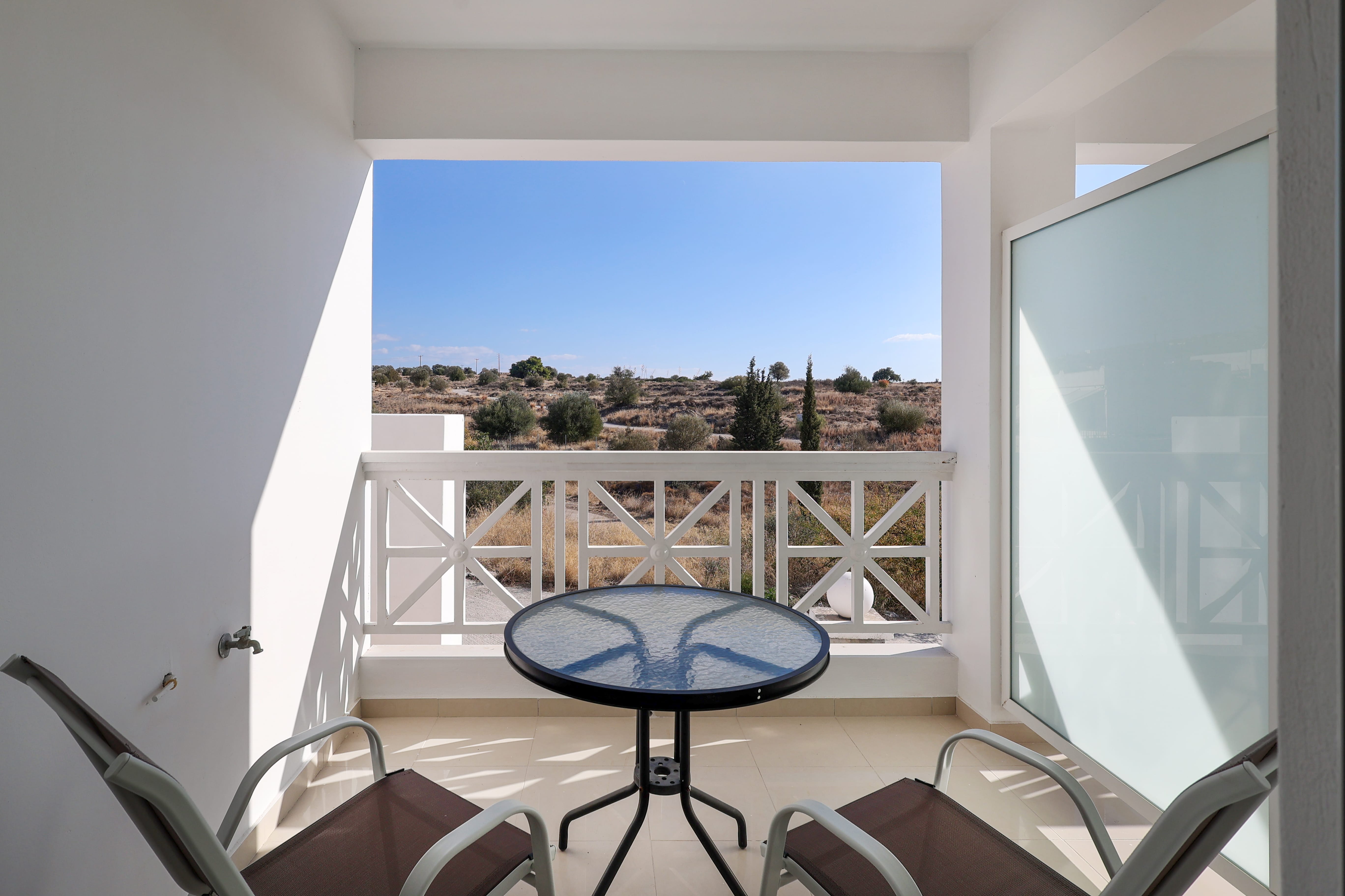 a table with a chair and a view of the ocean