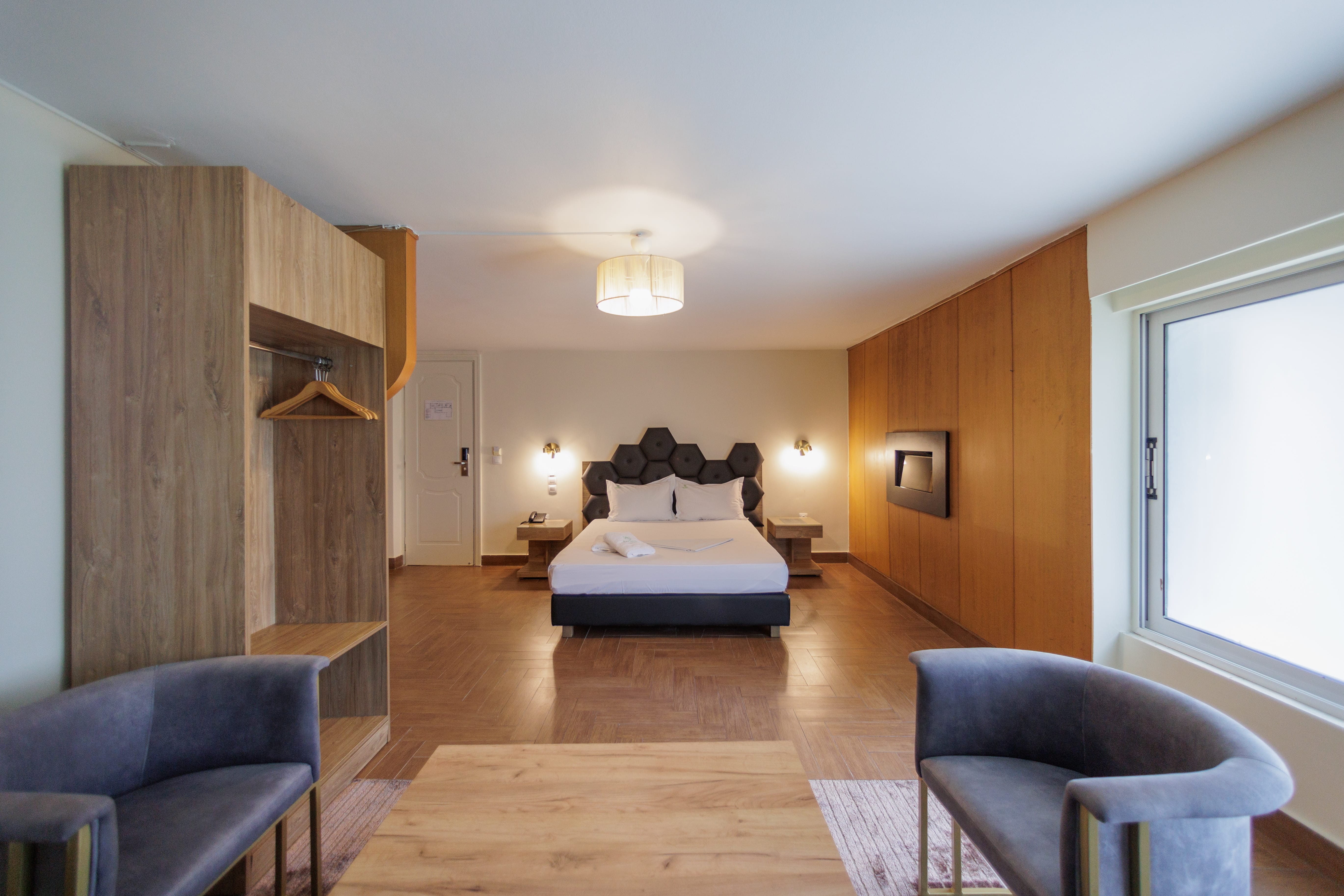 a room with a bed and chairs