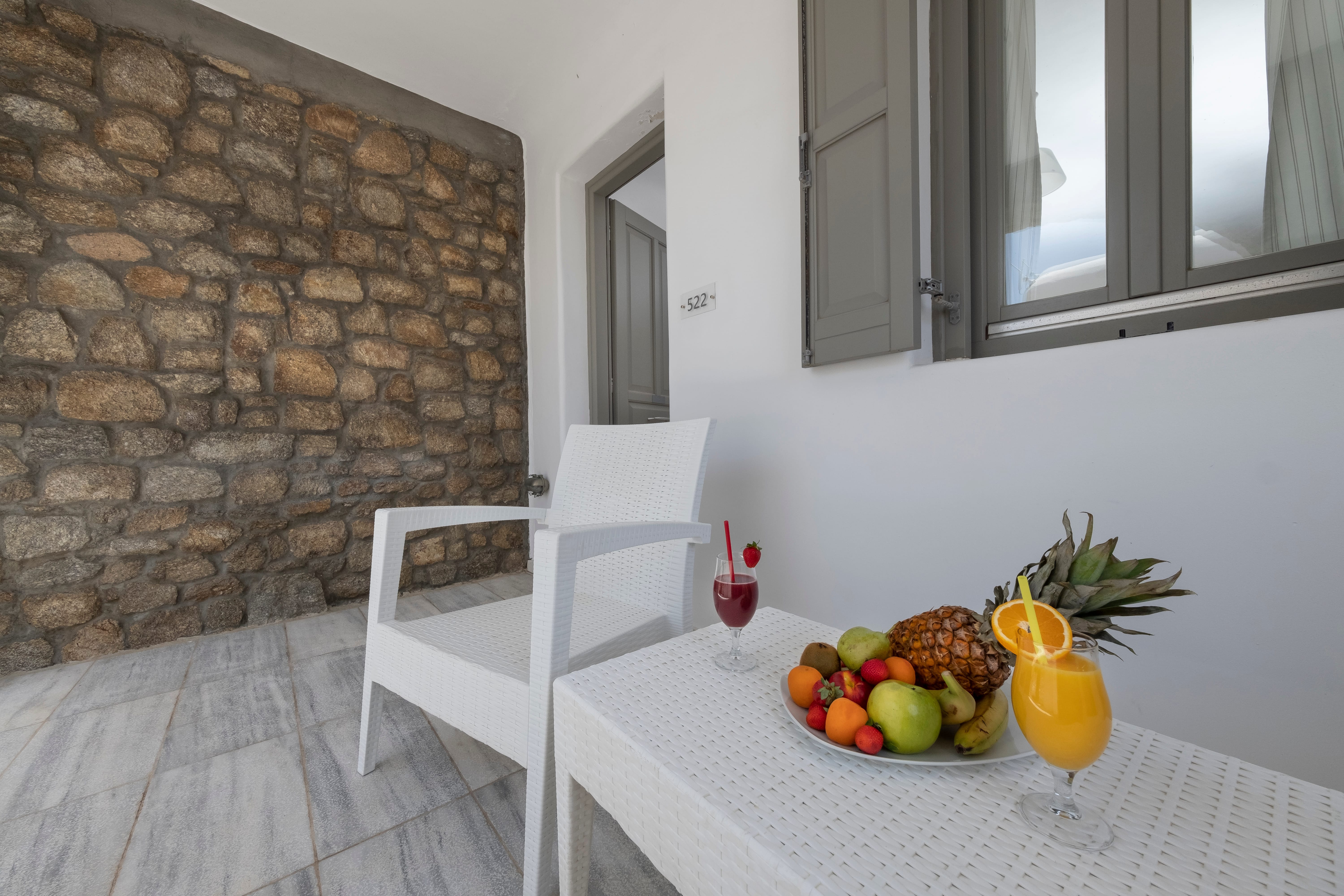 a table with a chair and a table with fruit on it
