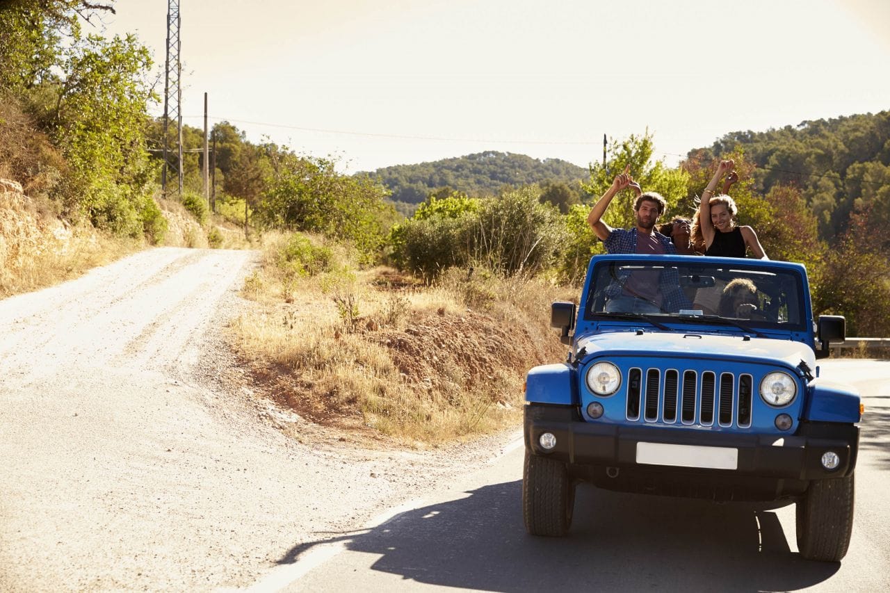 a group of people in a blue car on a road