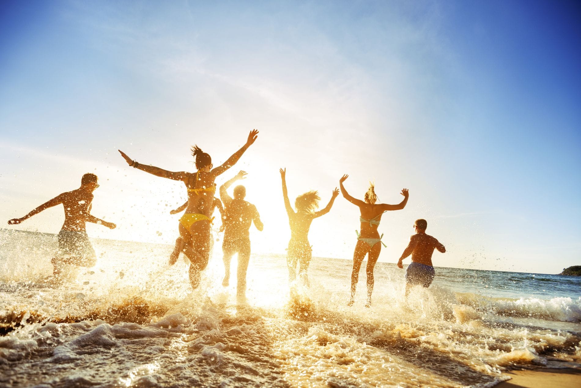a group of people jumping on a beach