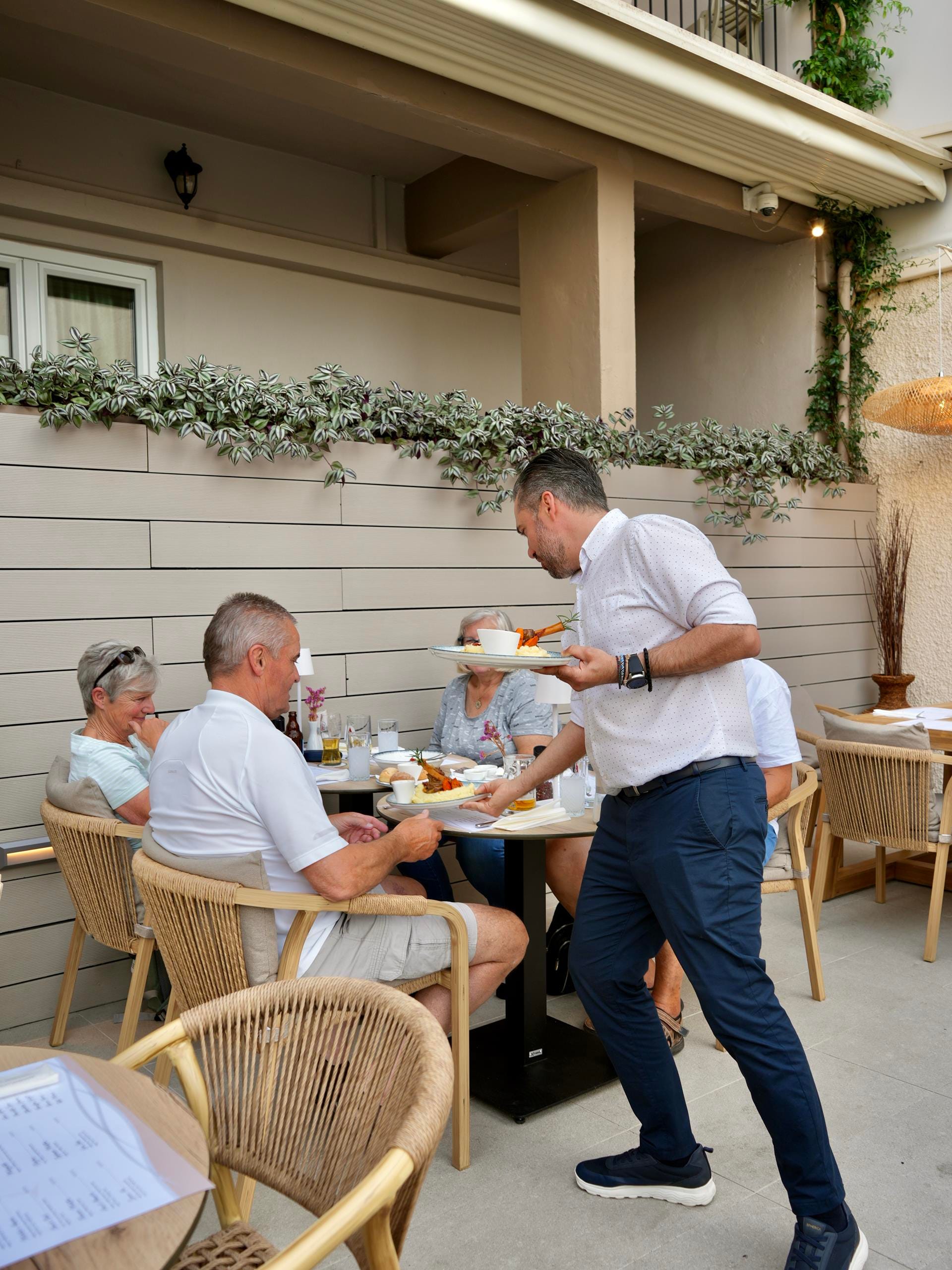 a person standing next to a person sitting at a table eating