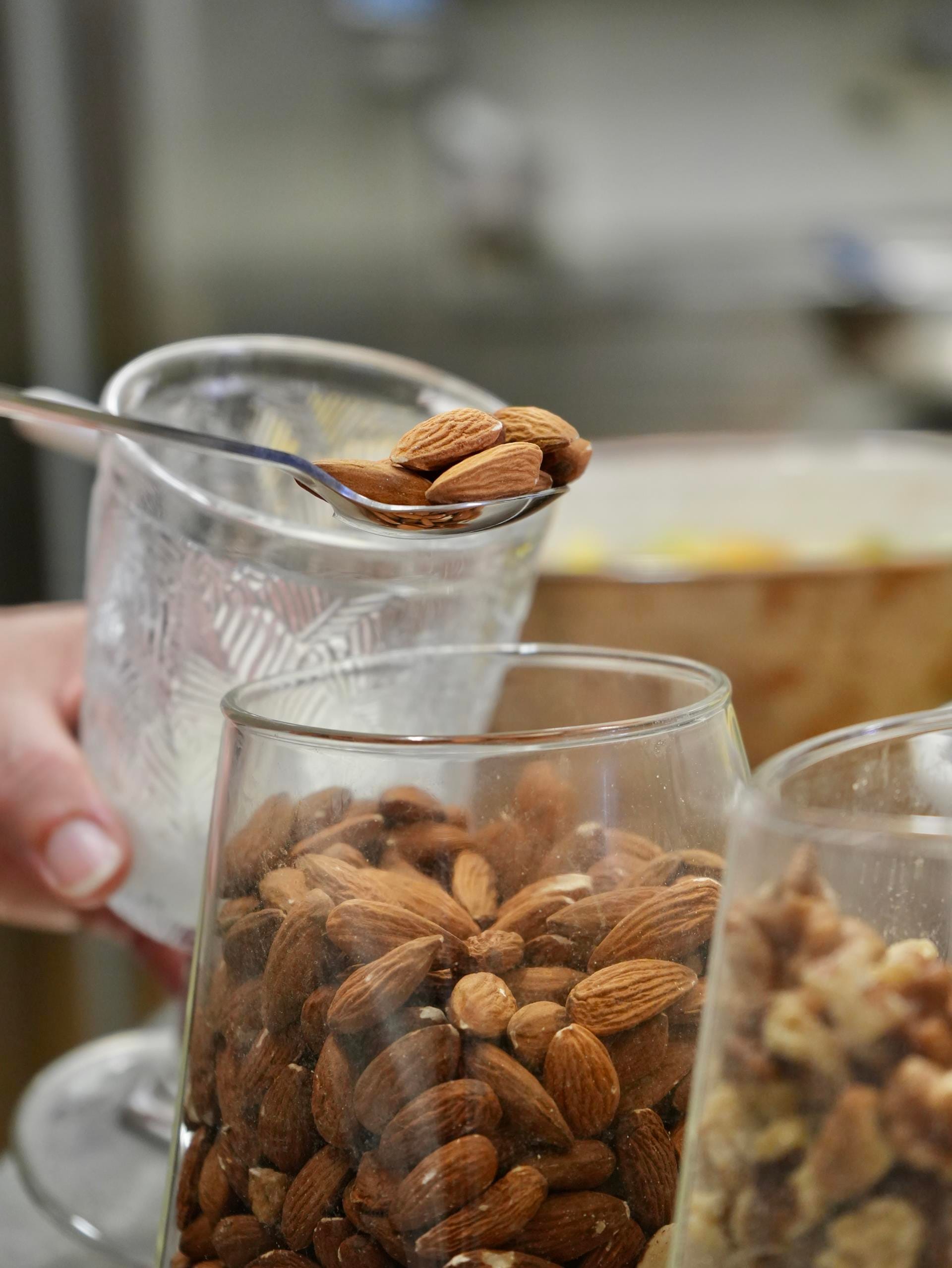 a hand holding a glass of milk with a spoon in it