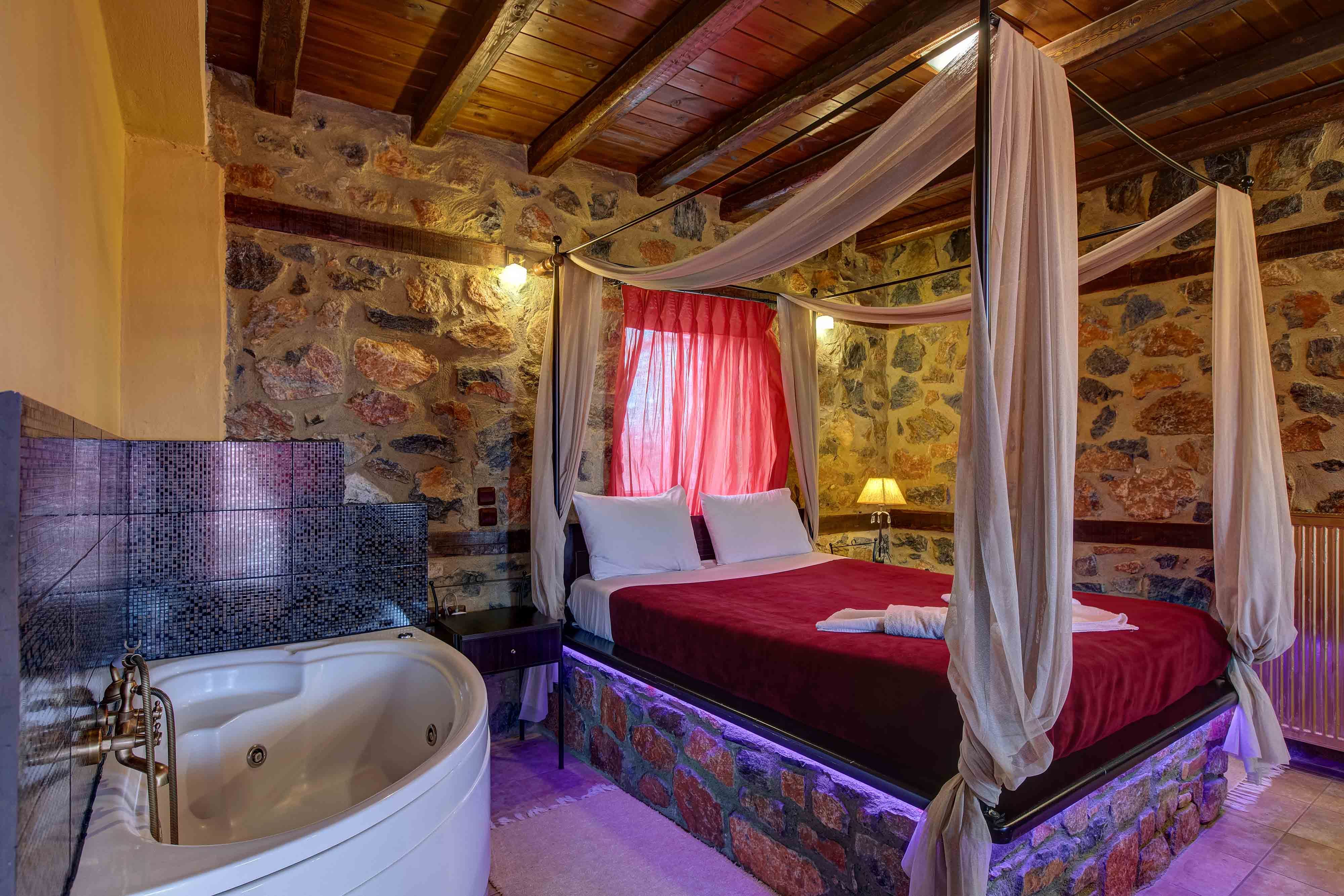 a bedroom with a red bed and a bathtub