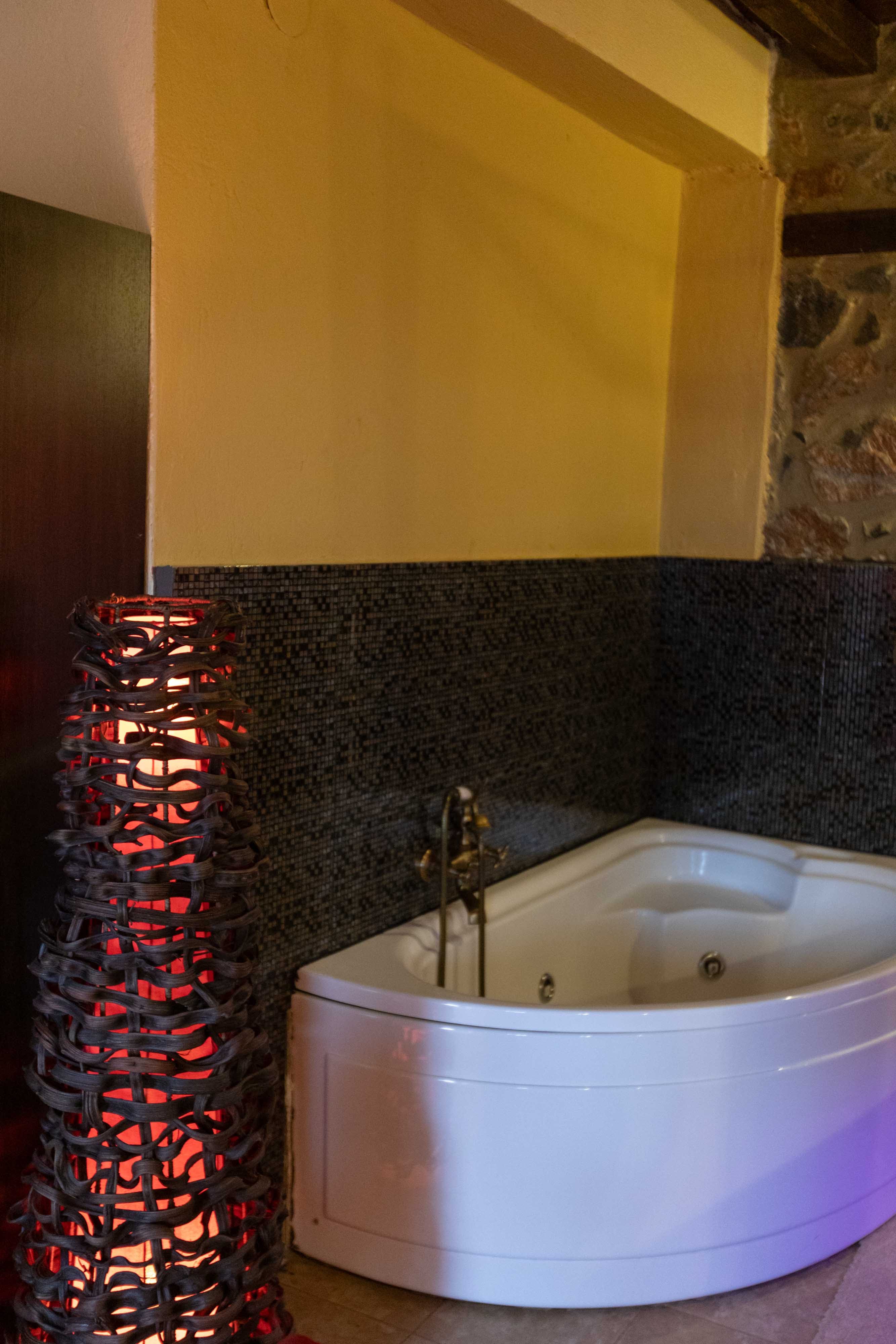 a bathtub with a vase on the side