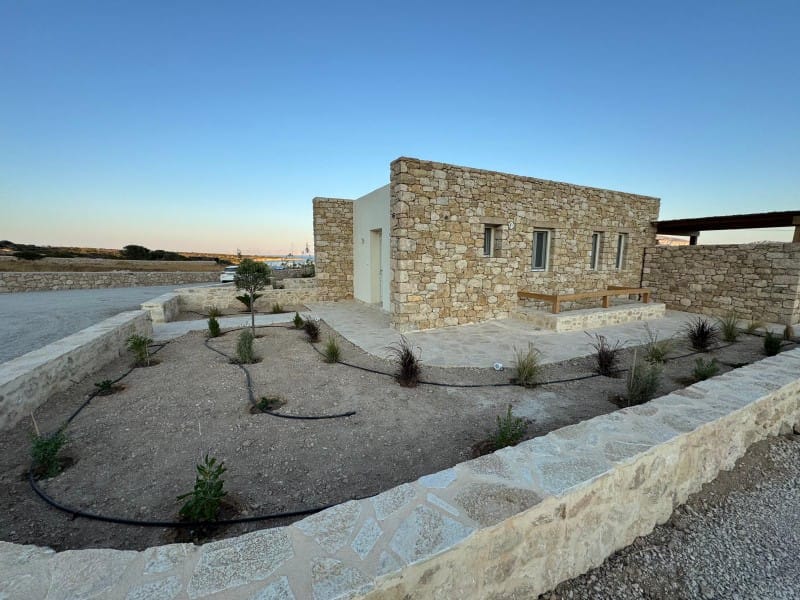 a stone building with a pool in front of it