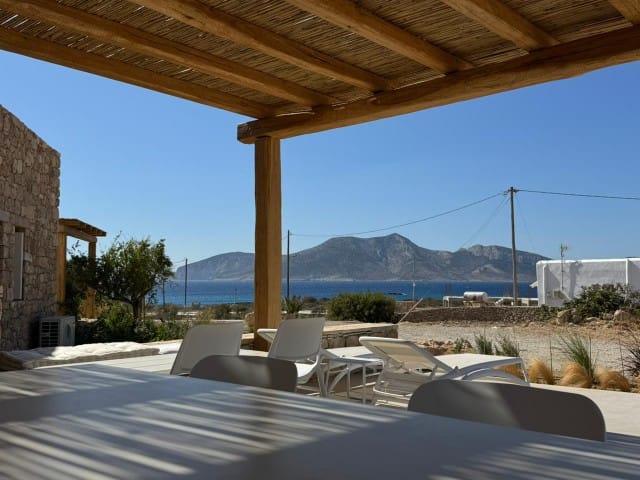 a deck with chairs and a body of water in the background
