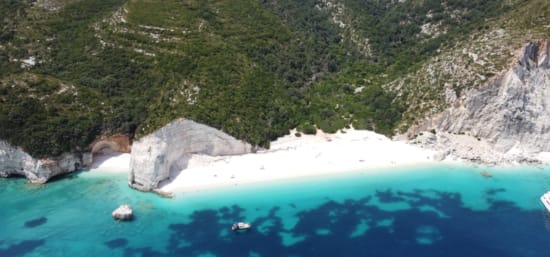 a body of water with a large rock in the middle