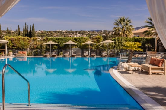 a pool with chairs and umbrellas