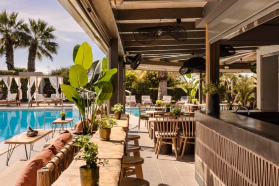 a pool and chairs next to a deck with plants and a deck