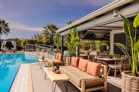 a pool and lounge chairs next to a house