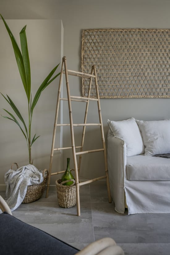 a room with a couch and a table with a basket and a plant