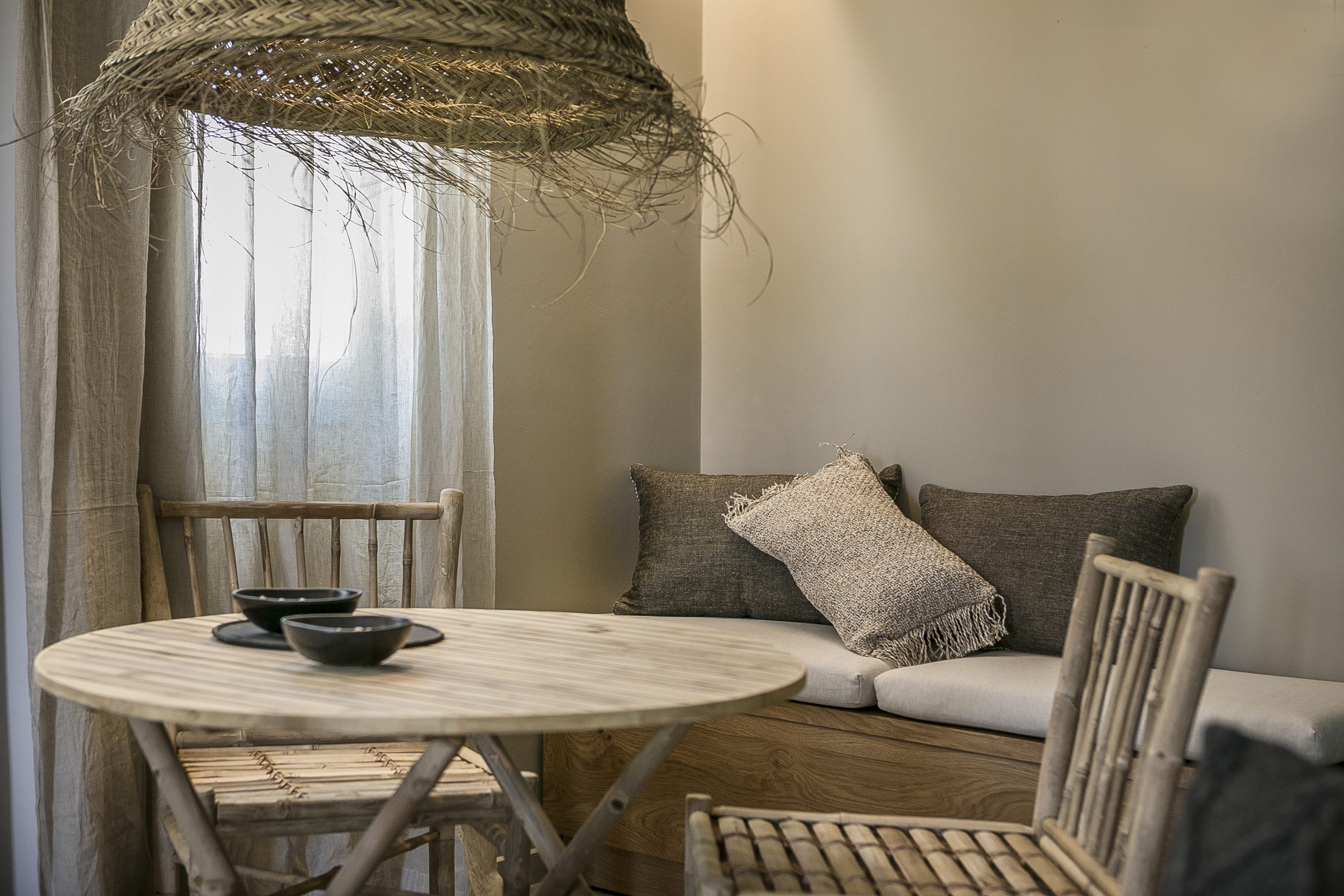 a table with a chair and a couch in a room with a window