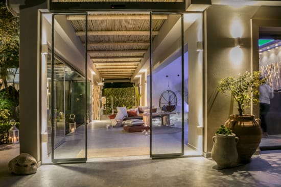 a glass door leading to a living room with a glass wall