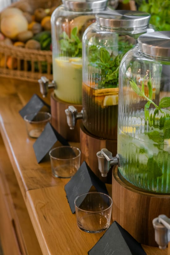 a table with a glass jar and a couple of glasses with liquid in it