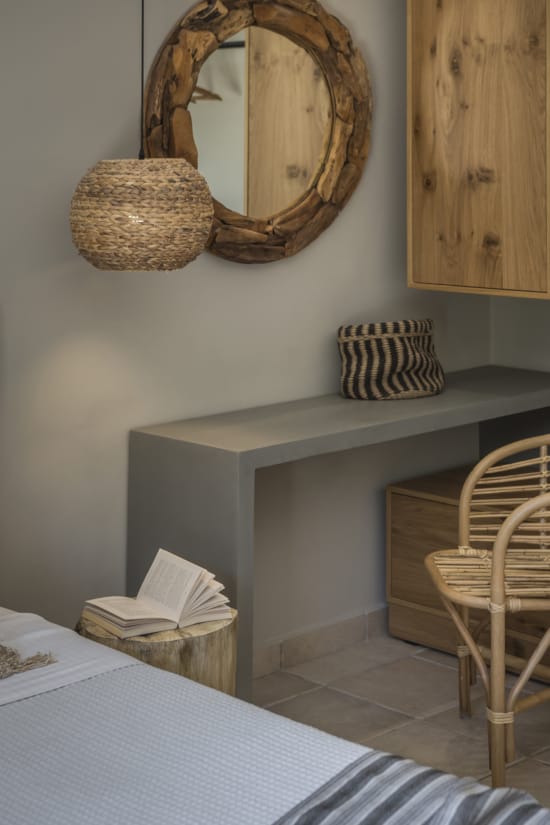a table with a basket and a chair in a room with a mirror